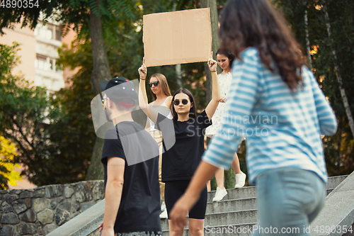Image of Dude with sign - woman stands protesting things that annoy her