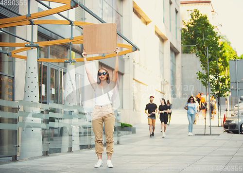 Image of Dude with sign - woman stands protesting things that annoy her