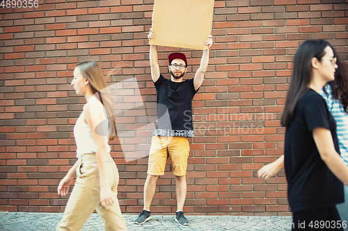 Image of Dude with sign - man stands protesting things that annoy him