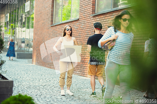 Image of Dude with sign - woman stands protesting things that annoy her