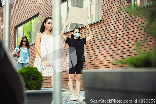 Image of Dude with sign - woman stands protesting things that annoy her