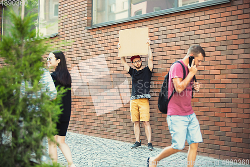 Image of Dude with sign - man stands protesting things that annoy him