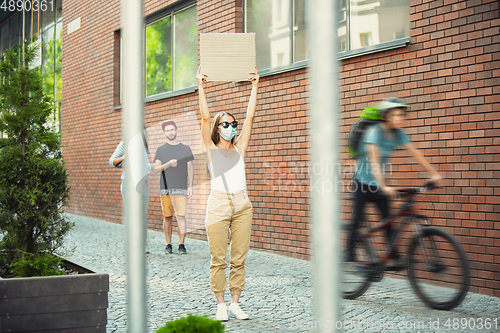 Image of Dude with sign - woman stands protesting things that annoy her