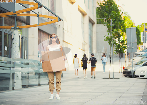 Image of Dude with sign - woman stands protesting things that annoy her