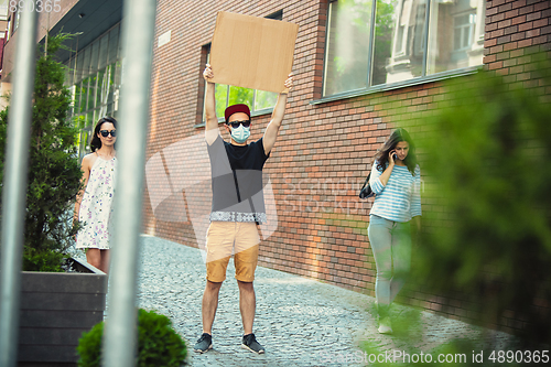 Image of Dude with sign - man stands protesting things that annoy him