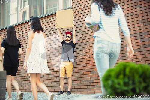 Image of Dude with sign - man stands protesting things that annoy him