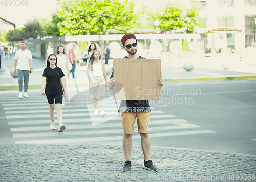 Image of Dude with sign - man stands protesting things that annoy him