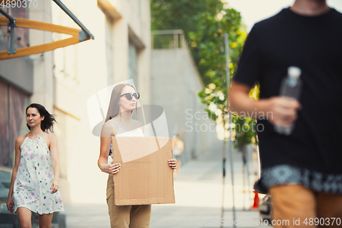 Image of Dude with sign - woman stands protesting things that annoy her