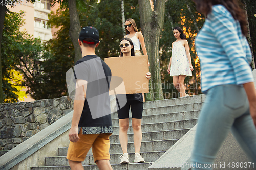 Image of Dude with sign - woman stands protesting things that annoy her