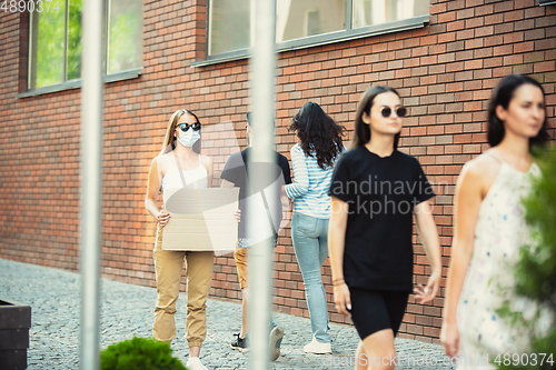 Image of Dude with sign - woman stands protesting things that annoy her