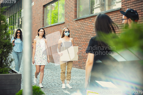 Image of Dude with sign - woman stands protesting things that annoy her