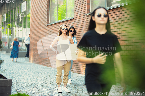 Image of Dude with sign - woman stands protesting things that annoy her