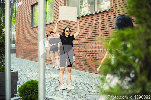 Image of Dude with sign - woman stands protesting things that annoy her