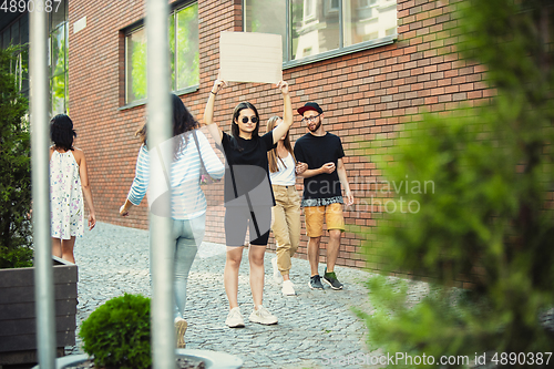 Image of Dude with sign - woman stands protesting things that annoy her