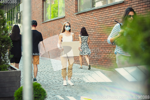 Image of Dude with sign - woman stands protesting things that annoy her