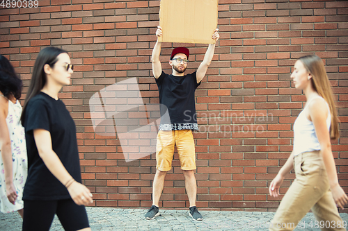 Image of Dude with sign - man stands protesting things that annoy him