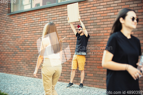 Image of Dude with sign - man stands protesting things that annoy him