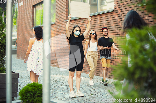 Image of Dude with sign - woman stands protesting things that annoy her