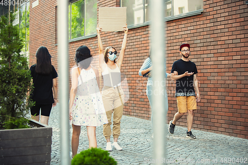 Image of Dude with sign - woman stands protesting things that annoy her