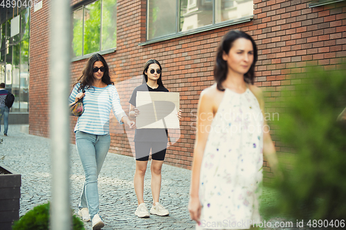 Image of Dude with sign - woman stands protesting things that annoy her