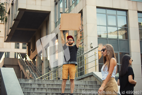 Image of Dude with sign - man stands protesting things that annoy him