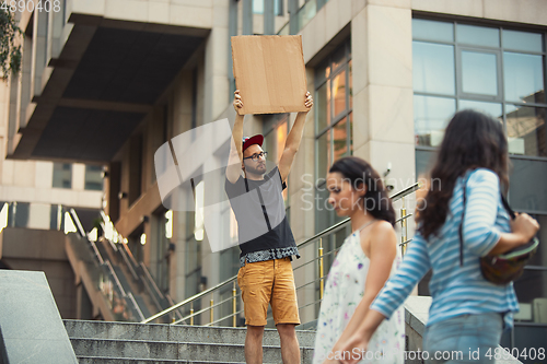 Image of Dude with sign - man stands protesting things that annoy him