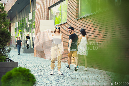 Image of Dude with sign - woman stands protesting things that annoy her