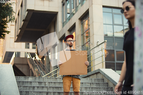 Image of Dude with sign - man stands protesting things that annoy him