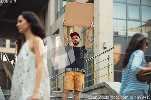 Image of Dude with sign - man stands protesting things that annoy him