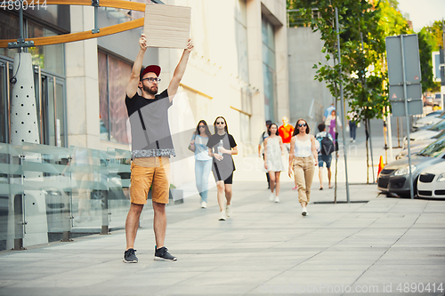 Image of Dude with sign - man stands protesting things that annoy him