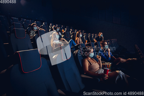 Image of Cinema, movie theatre during quarantine. Coronavirus pandemic safety rules, social distance during movie watching