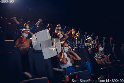 Image of Cinema, movie theatre during quarantine. Coronavirus pandemic safety rules, social distance during movie watching