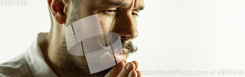 Image of Caucasian young man\'s close up cropped shot on studio background, flyer