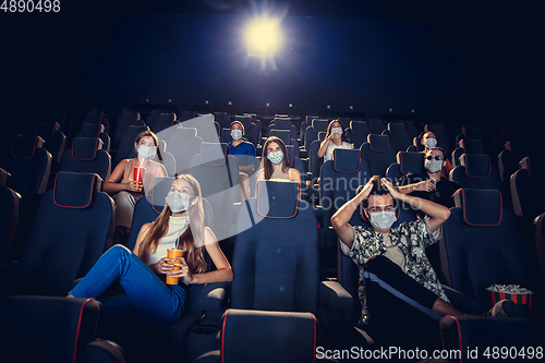 Image of Cinema, movie theatre during quarantine. Coronavirus pandemic safety rules, social distance during movie watching