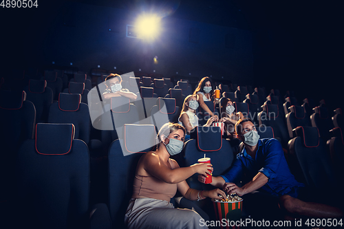 Image of Cinema, movie theatre during quarantine. Coronavirus pandemic safety rules, social distance during movie watching