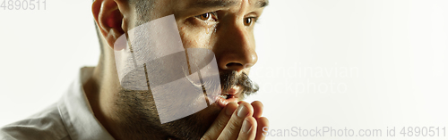Image of Caucasian young man\'s close up cropped shot on studio background, flyer