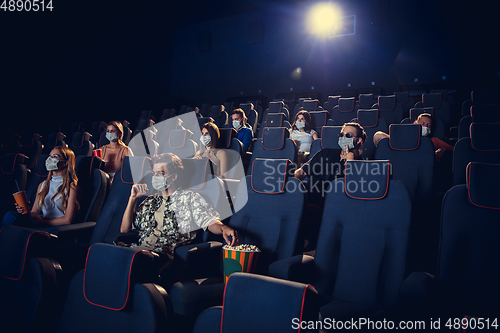 Image of Cinema, movie theatre during quarantine. Coronavirus pandemic safety rules, social distance during movie watching