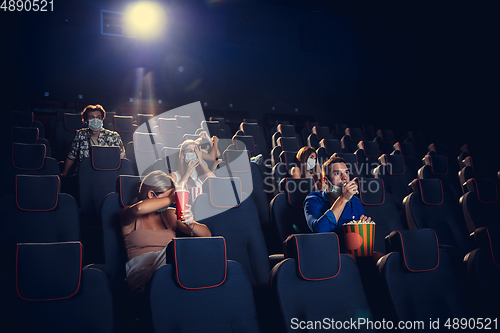 Image of Cinema, movie theatre during quarantine. Coronavirus pandemic safety rules, social distance during movie watching