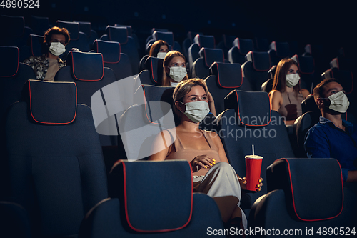 Image of Cinema, movie theatre during quarantine. Coronavirus pandemic safety rules, social distance during movie watching