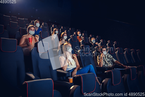 Image of Cinema, movie theatre during quarantine. Coronavirus pandemic safety rules, social distance during movie watching