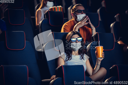 Image of Cinema, movie theatre during quarantine. Coronavirus pandemic safety rules, social distance during movie watching