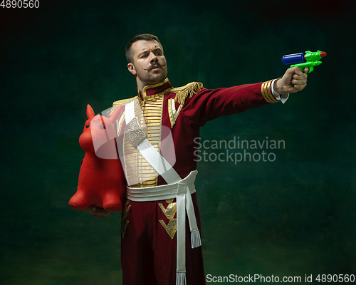 Image of Young man as Nicholas II on dark green background. Retro style, comparison of eras concept.