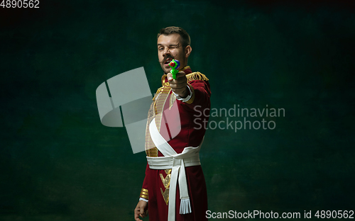 Image of Young man as Nicholas II on dark green background. Retro style, comparison of eras concept.