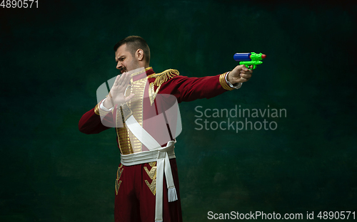 Image of Young man as Nicholas II on dark green background. Retro style, comparison of eras concept.