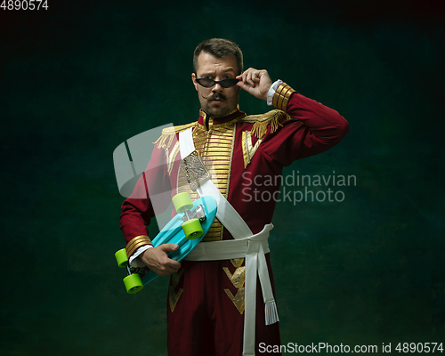 Image of Young man as Nicholas II on dark green background. Retro style, comparison of eras concept.