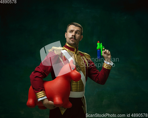 Image of Young man as Nicholas II on dark green background. Retro style, comparison of eras concept.