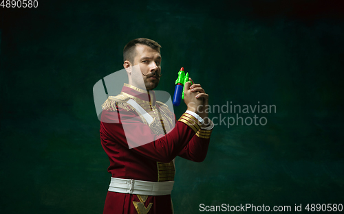 Image of Young man as Nicholas II on dark green background. Retro style, comparison of eras concept.