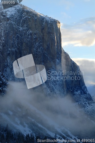 Image of El Capitan illuminated by rising sun on a misty morning