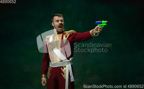 Image of Young man as Nicholas II on dark green background. Retro style, comparison of eras concept.