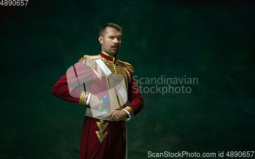 Image of Young man as Nicholas II on dark green background. Retro style, comparison of eras concept.